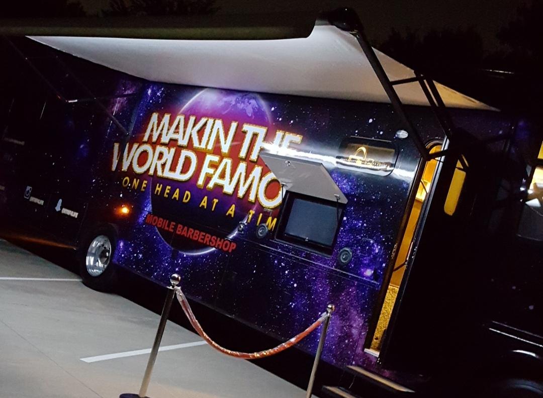 The mobile barbershop at night behind a red carpet
